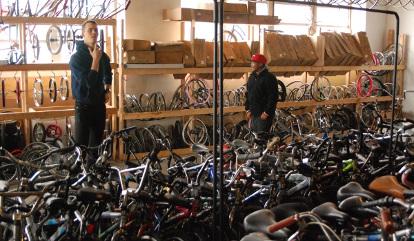 Ham (left) helps Maurice (right) pick out a bike from the warehouse to build up and earn.
